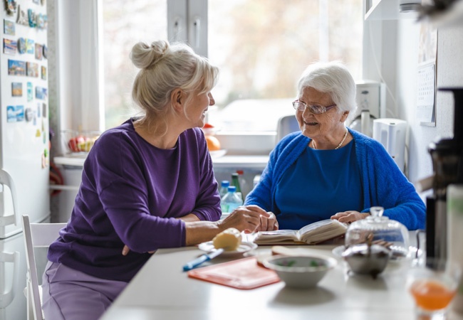 2 femmes dont une âgée qui discutent et rigolent