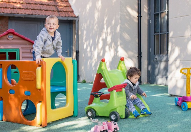 Des enfants qui jouent en extérieur avec des jeux de crèche