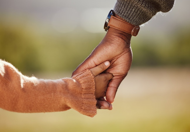 un enfant et un adulte qui se tiennent la main