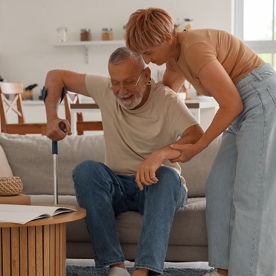 Femme qui aide un homme âgé à se lever