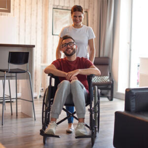 Femme qui pousse un homme en fauteuil roulant