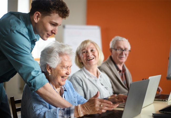 groupe de senior qui apprend à utiliser un ordinateur