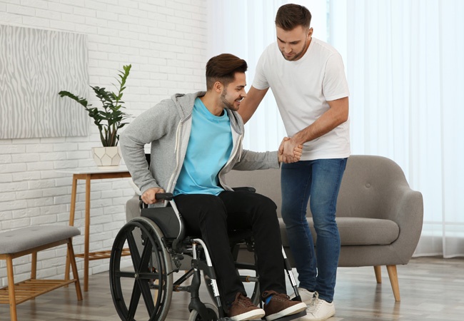 homme qui aide un homme en fauteuil roulant à se déplacer