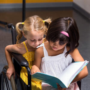 petites filles en fauteuil roulant qui lisent un livre