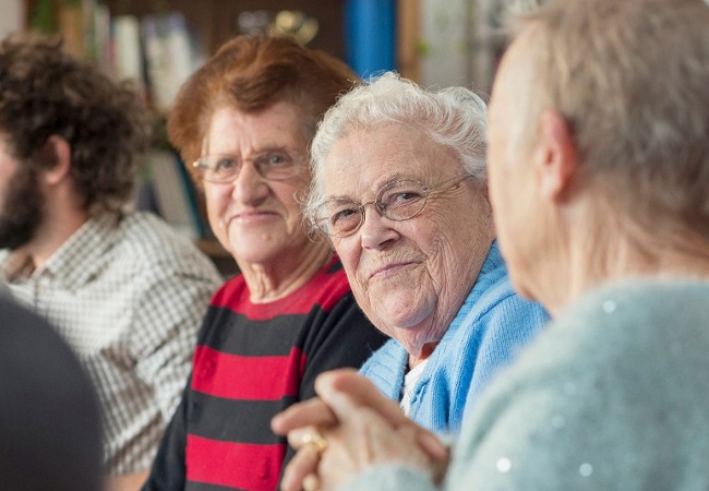 Personnes âgées qui discutent et sourient