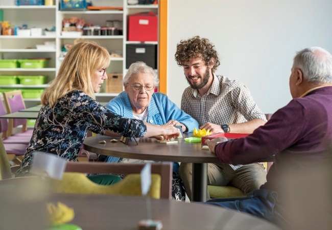 Soignant, famille et personne âgée qui jouent