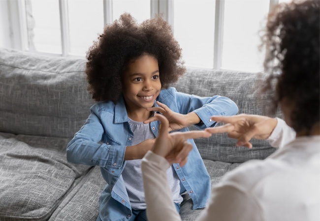 Une enfant heureuse qui parle en langue des signes