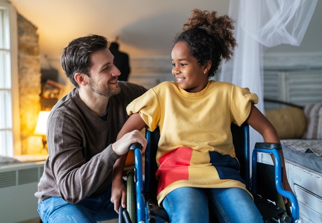 enfant en fauteuil roulant qui sourit