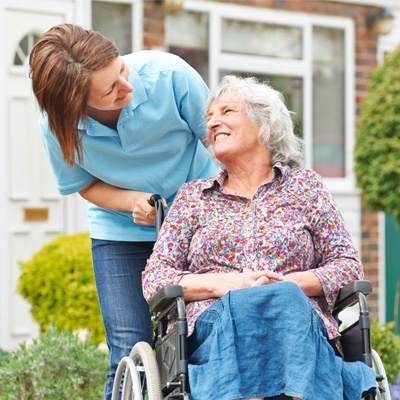 Une jeune femme et une dame en situation de handicap se sourient