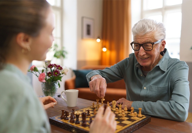 Un homme âgé qui joue aux échecs avec une femme