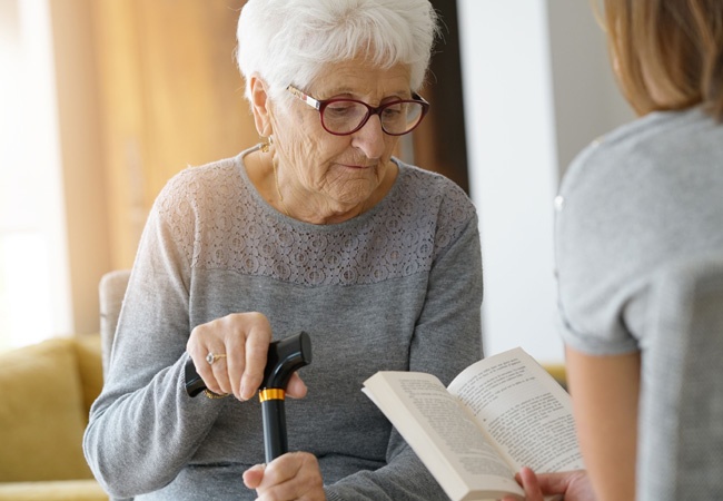 Une dame qui lit un livre à une dame âgée