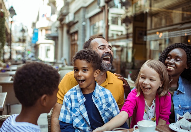 Une famille recomposée qui rigole et discute dans un bar