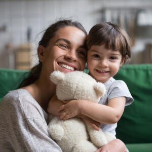 Une maman et sa fille qui sourient et se font un câlin