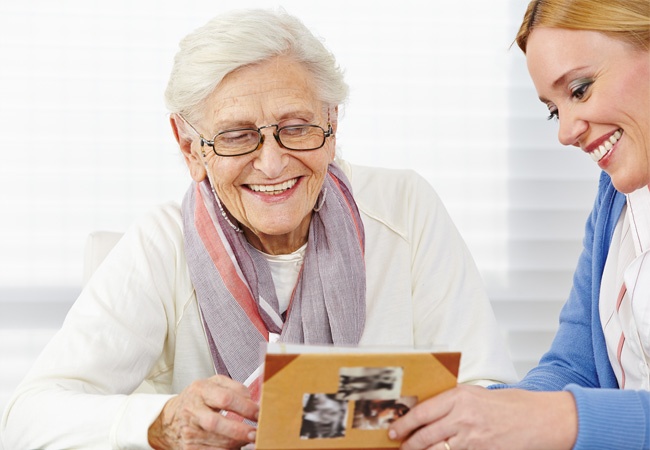 dame qui montre des photos à une dame âgée souriante