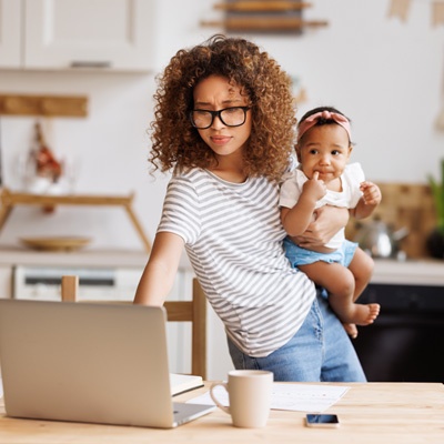 femme qui travaille et qui tient son bébé dans les bras