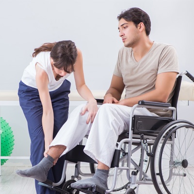 homme triste en fauteuil qui se fait aider