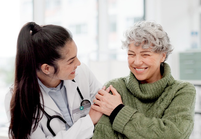 médecin qui rigole avec une dame en consultation