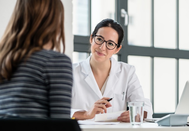 médecin souriante qui parle avec une femme