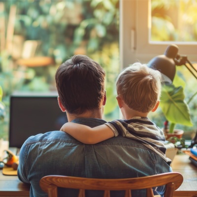 papa seul avec son fils sur les genoux de dos à son bureau