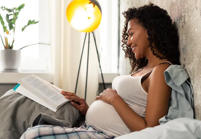 une femme enceinte heureuse qui lit